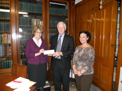Cherry Bamberg (left) presents City Archivist Paul Campbell and City Clerk Anna Stetson with a check for $1,000.